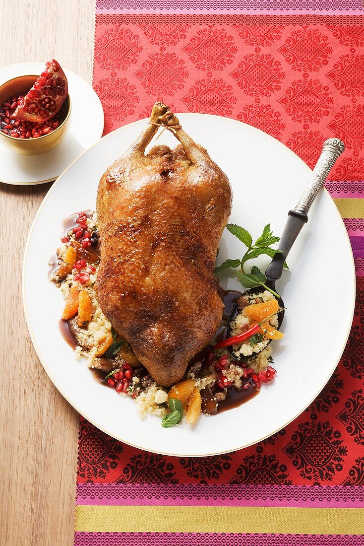 Roast duck with fruits and chilli on a bed of couscous