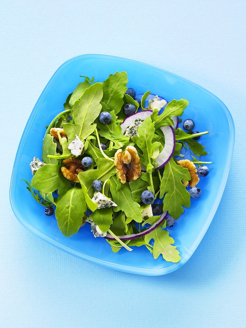 Mixed leaf salad with nuts, onions and blueberries, seen from above