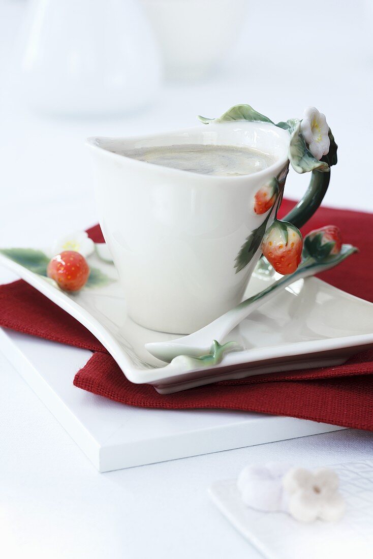 A cup with a strawberry handle