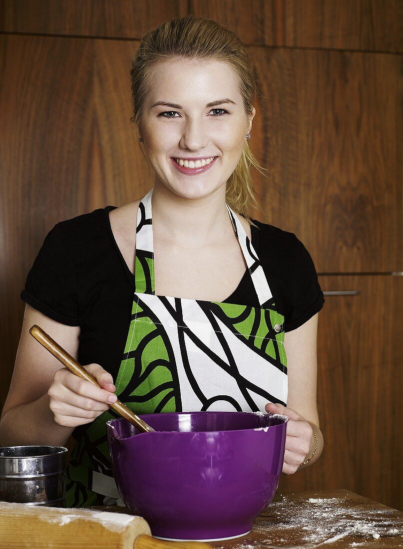 Woman with mixing bowl and mixing spoon