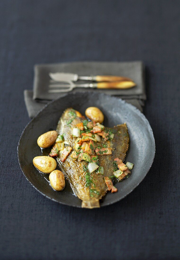 Fried plaice with bacon, onion and potatoes