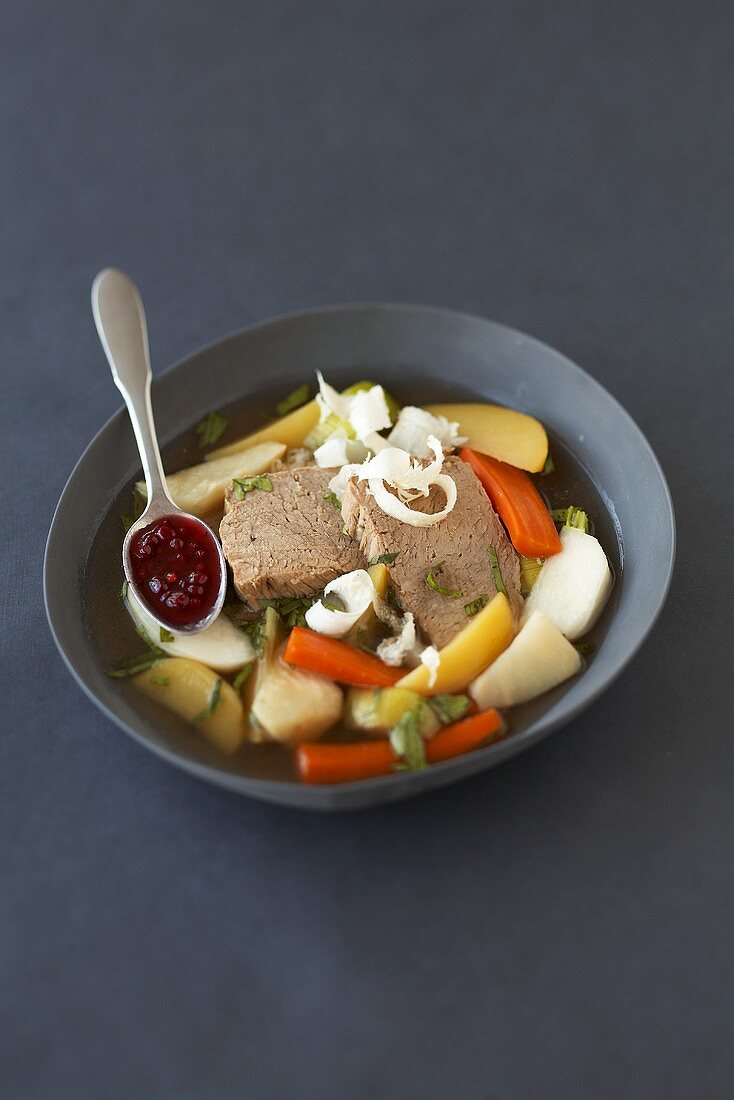 Boiled veal in bouillon with vegetables and cranberries