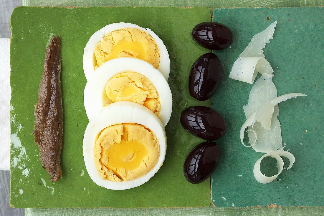 Sardellenfilet, gekochte Eier, Oliven und Parmesanspäne