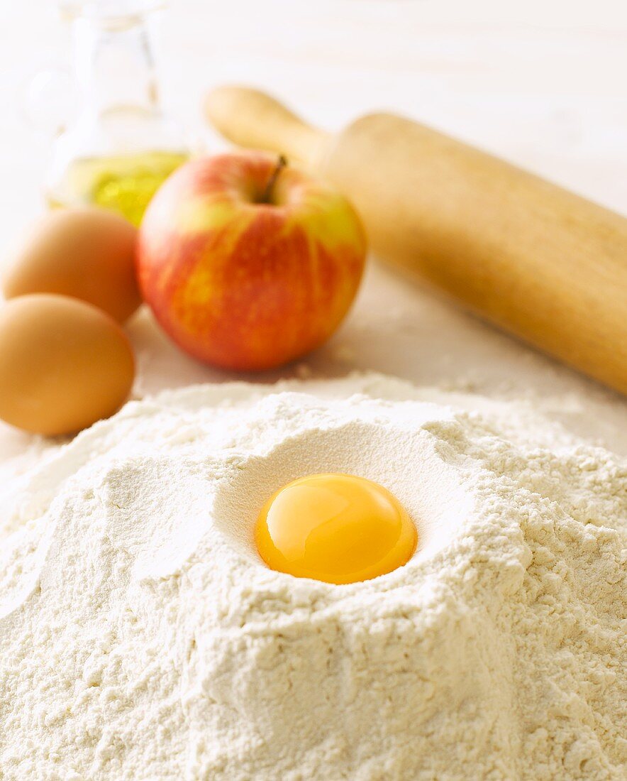 Egg yolk, flour, eggs, apple, rolling pin and oil