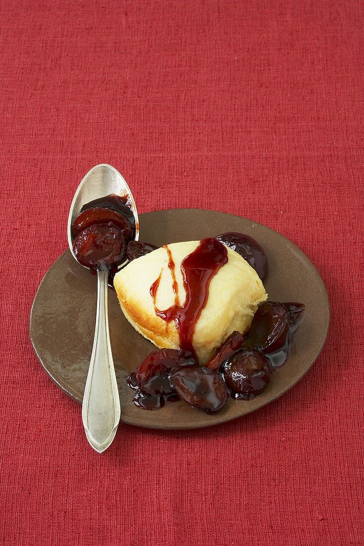 Dampfnudel (steamed dumpling) with stewed plums