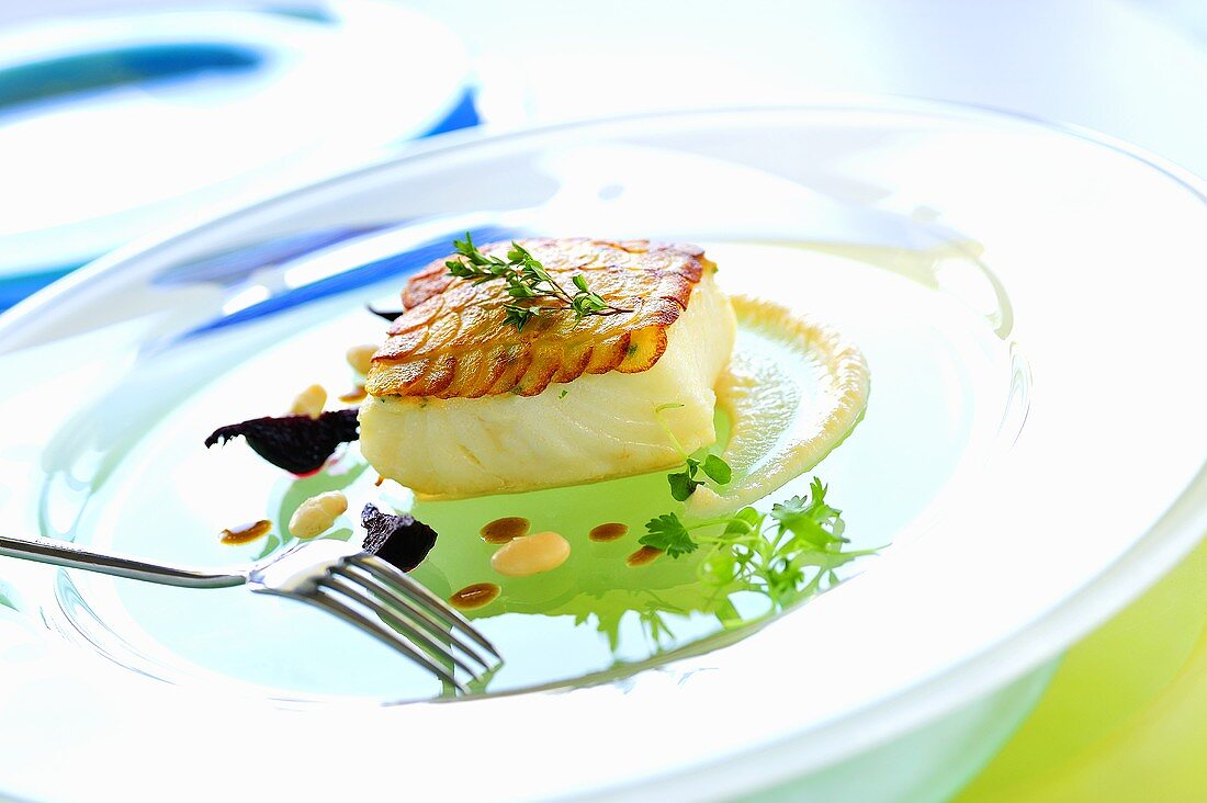 Cod fillet with potato crust on cauliflower cream