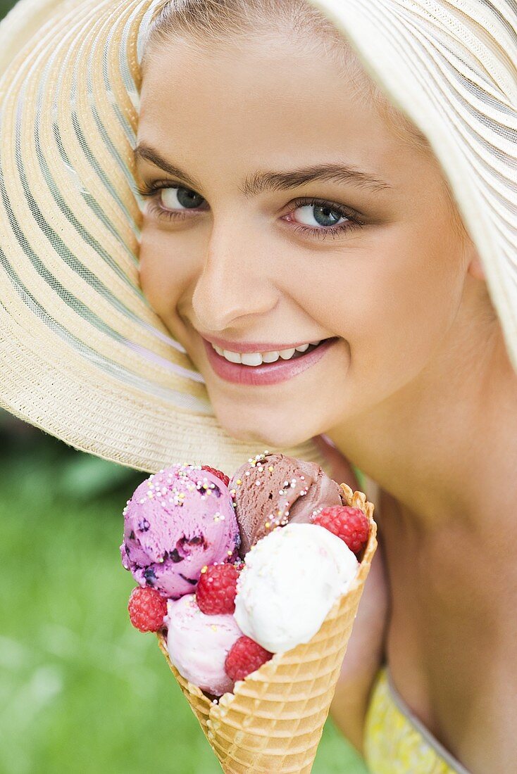 Woman in straw hat holding ice cream cone