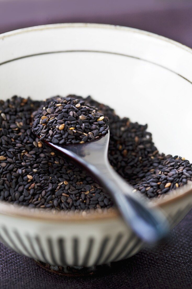 Black sesame seeds in a bowl with spoon