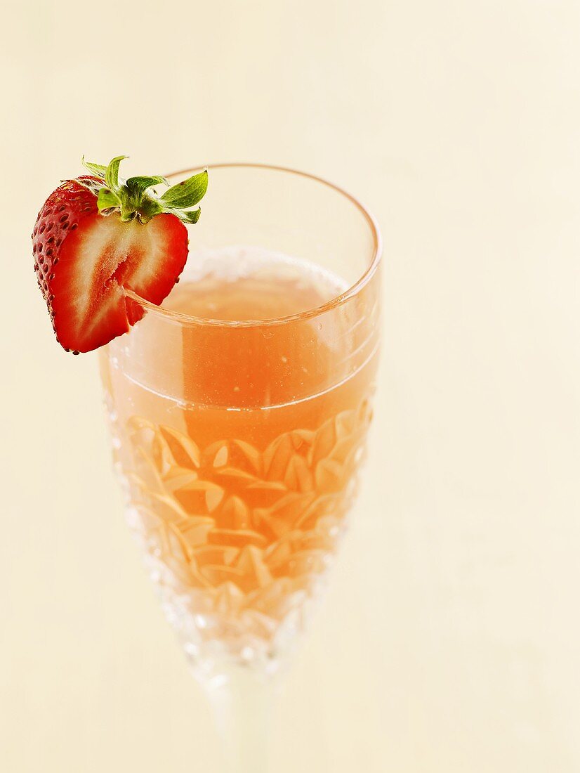Rhubarb drink with strawberry on glass rim