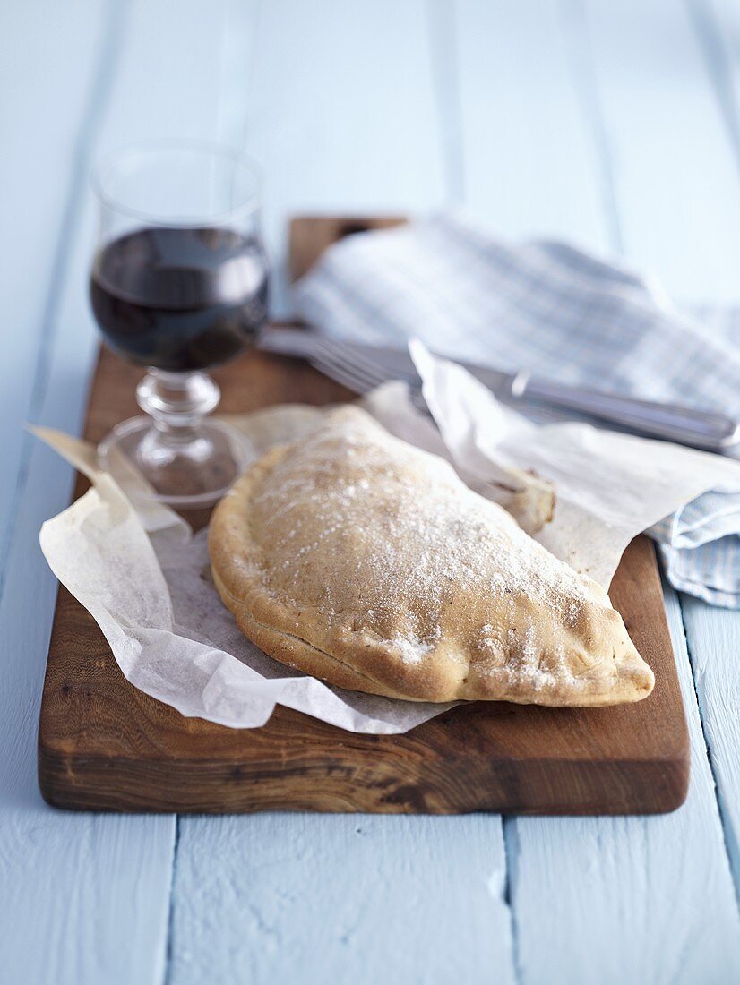 Calzone auf rustikalem Schneidebrett