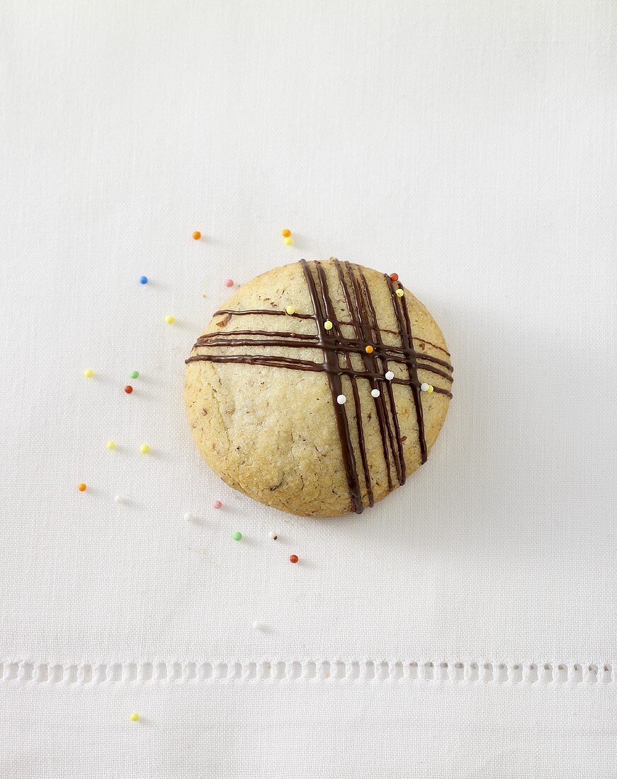 Christmas biscuit with chocolate drizzle and sprinkles