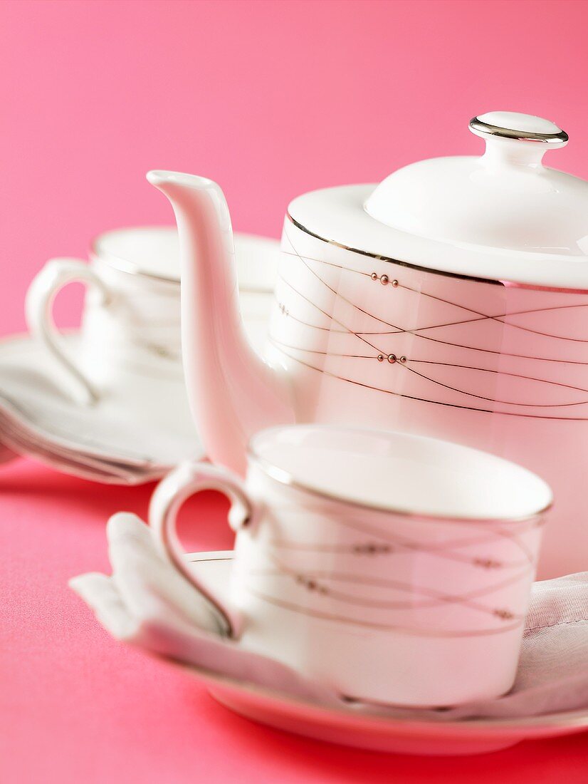 Teapot and two teacups and saucers