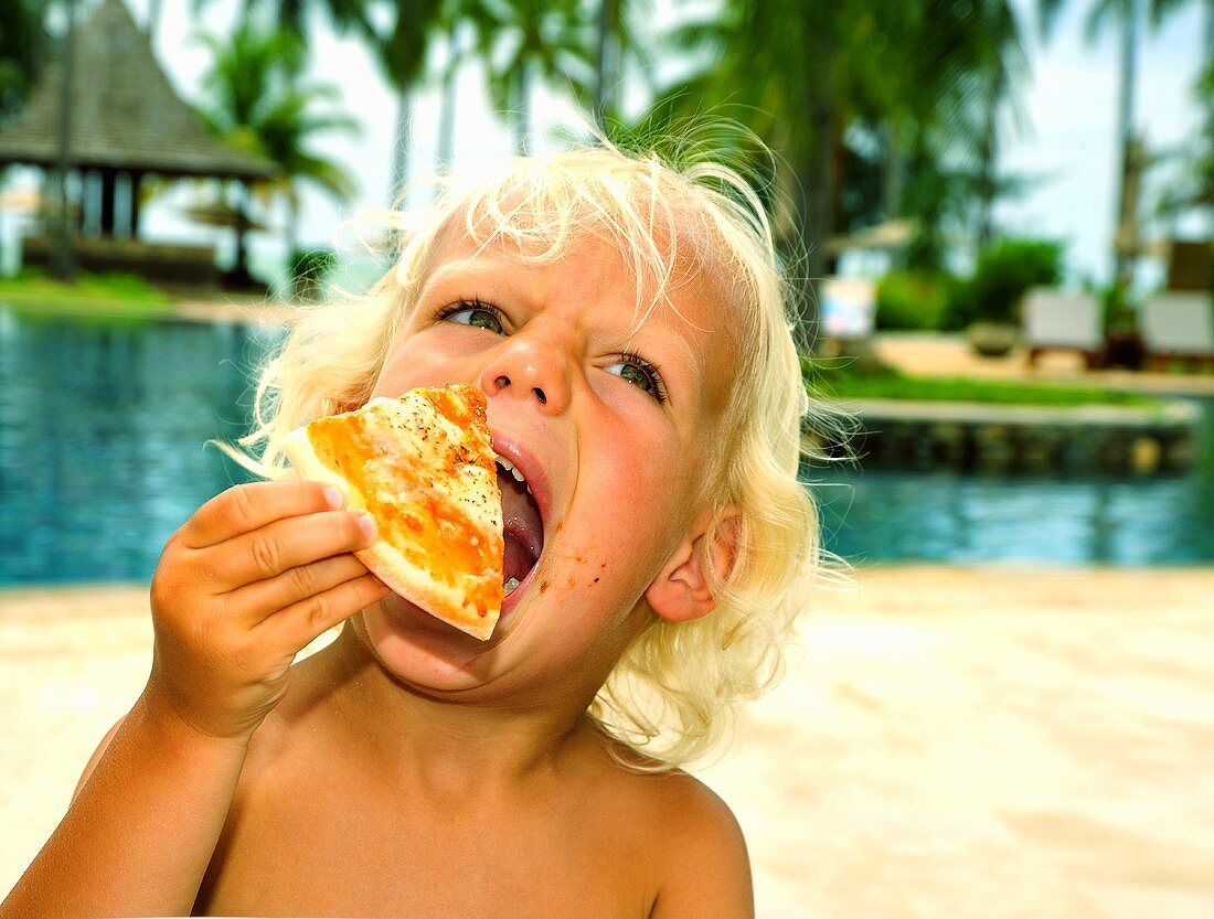 Child eating a slice of pizza