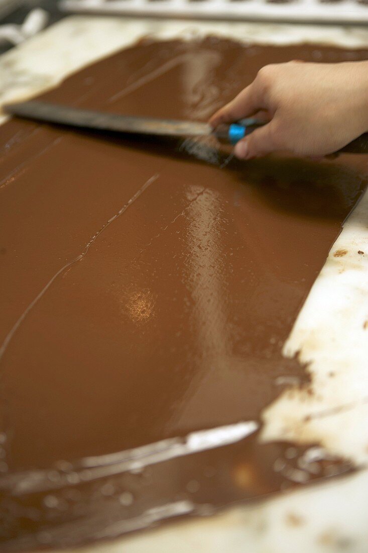 Spreading chocolate on a marble slab