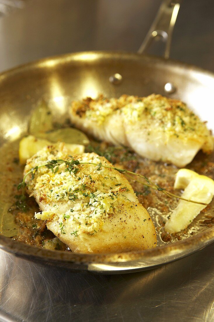 Halibut with panko crust sizzling in a frying pan