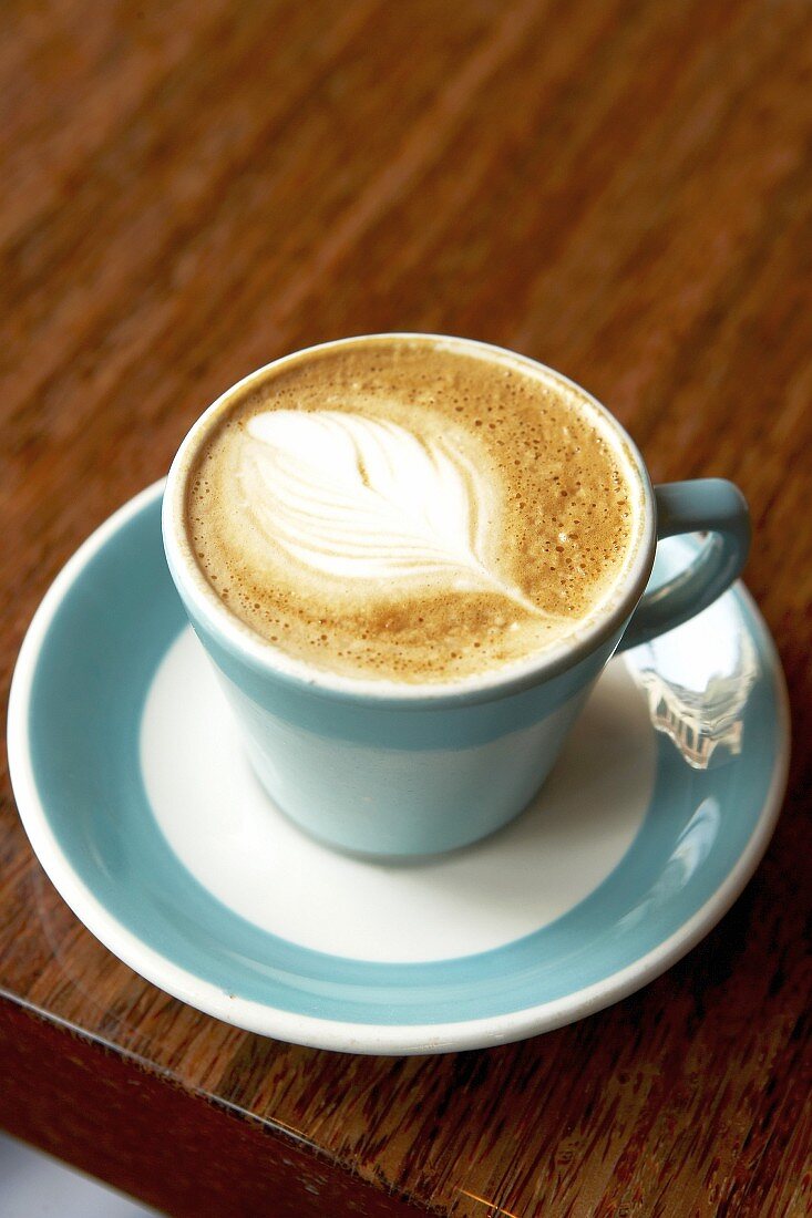 A cup of caffe latte with a pattern in the milk foam