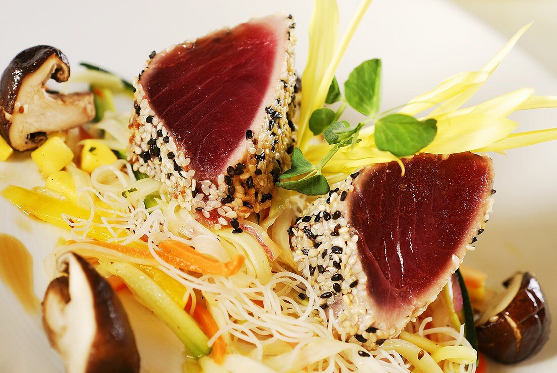 Seared tuna fillets with sesame seeds on Asian vegetables