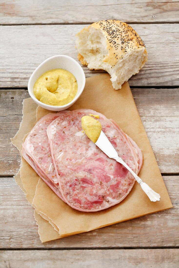 Sliced brawn with mustard and bread roll