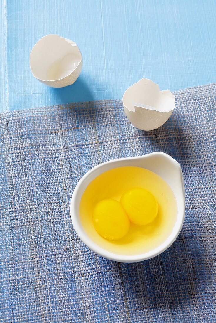 Double-yolked egg, broken into a dish