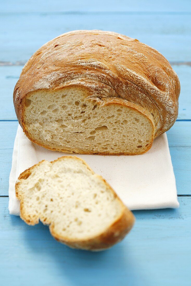 A loaf of bread, partly sliced