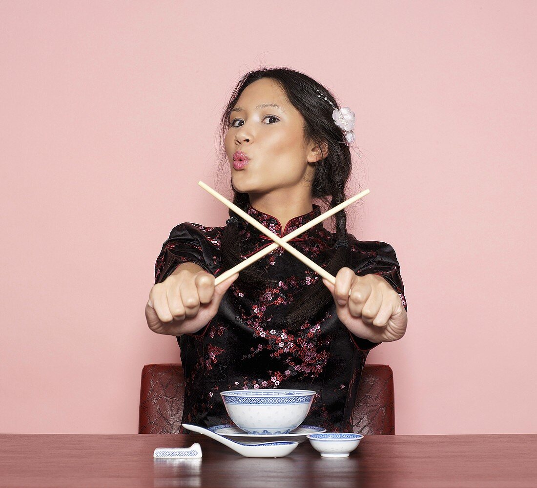 Asiatische Frau mit Essstäbchen