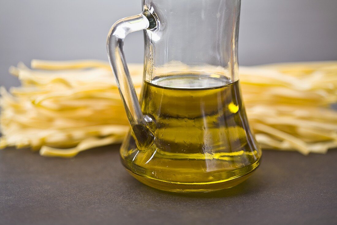 Nudeln mit einer Karaffe Olivenöl