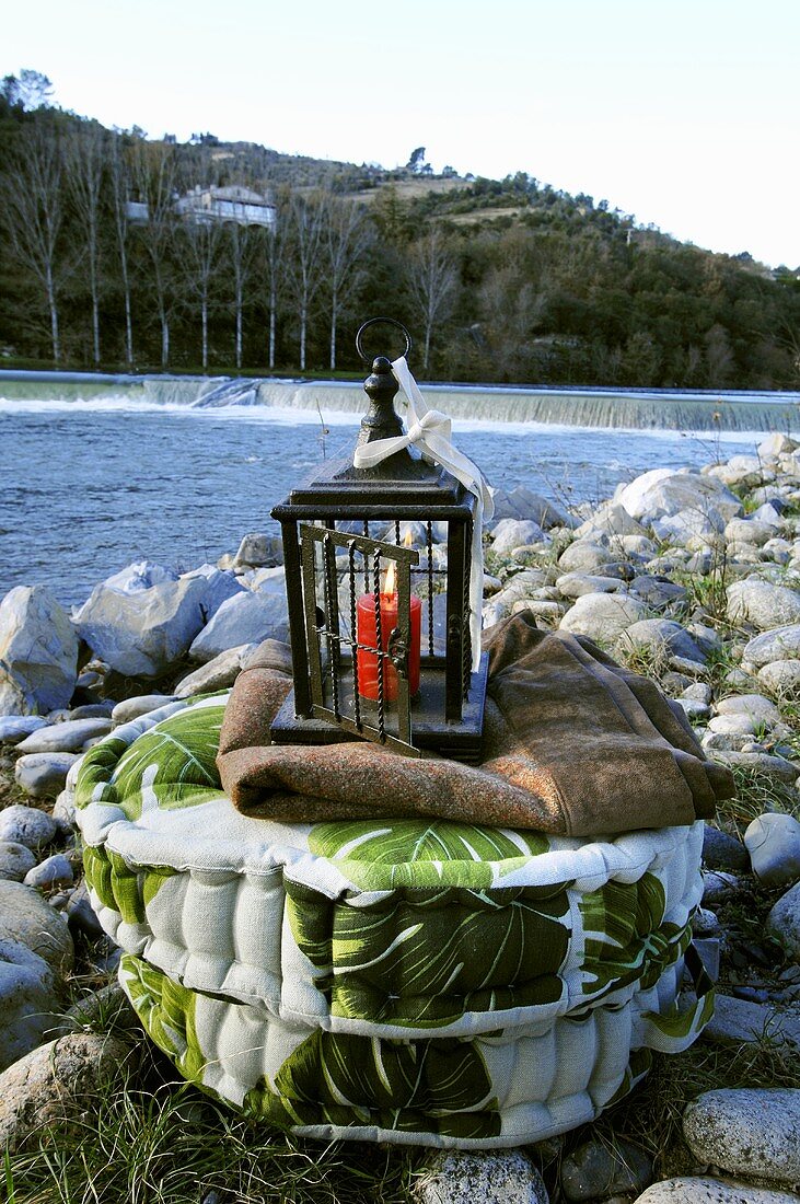 Floor cushion with lantern by river