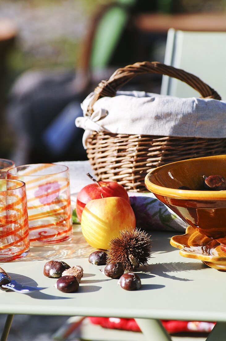 Sweet chestnuts and apples on a garden table