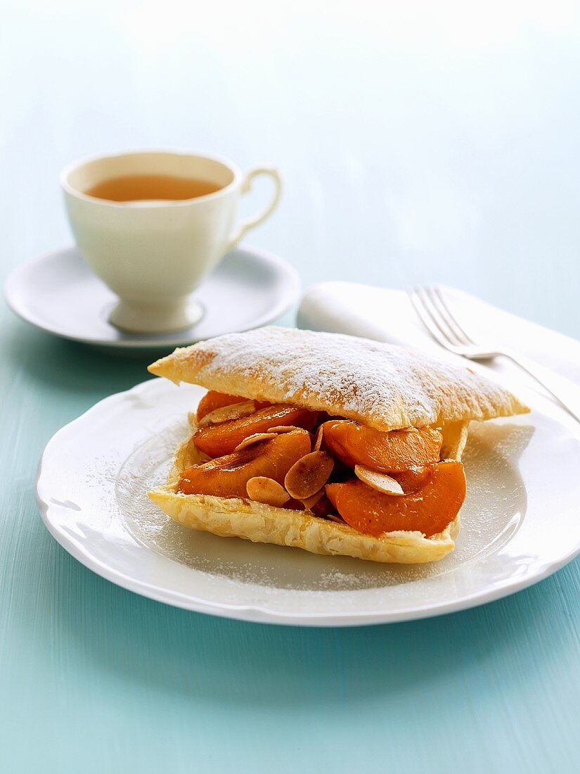 Puff pastry filled with apricots & flaked almonds, cup of tea