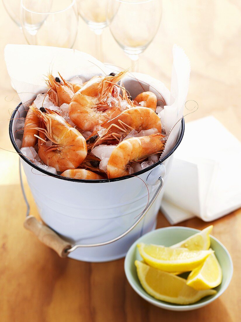 Cooked prawns in bucket, lemon wedges