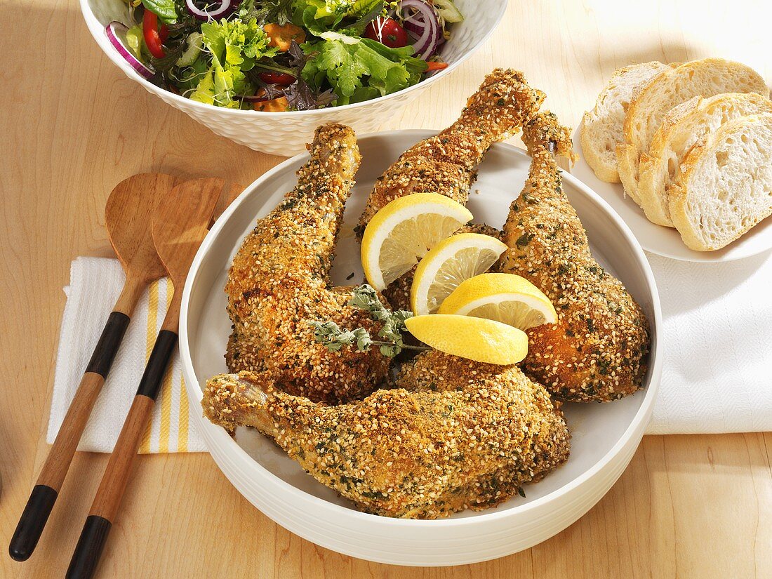 Breaded chicken legs with salad leaves and white bread