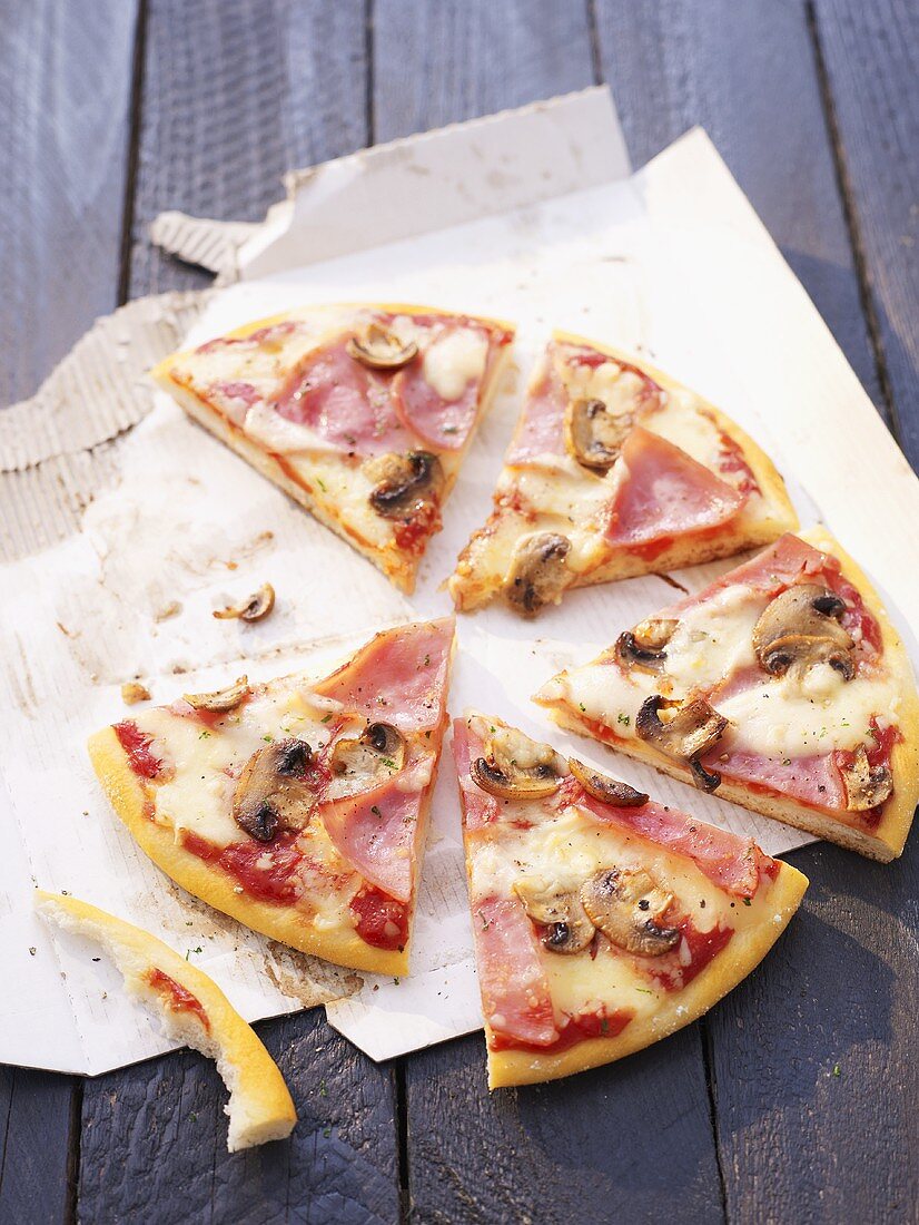 Pizza mit Schinken und Champignons, in Stücke geschnitten