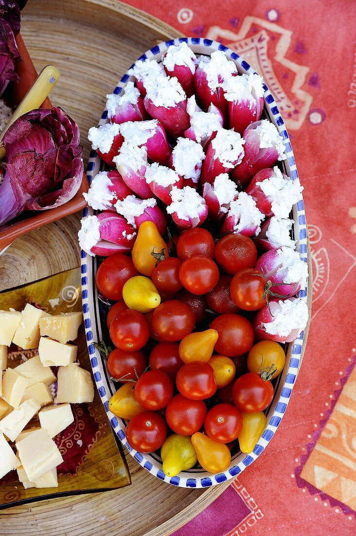 Radishes stuffed with soft cheese, cherry tomatoes