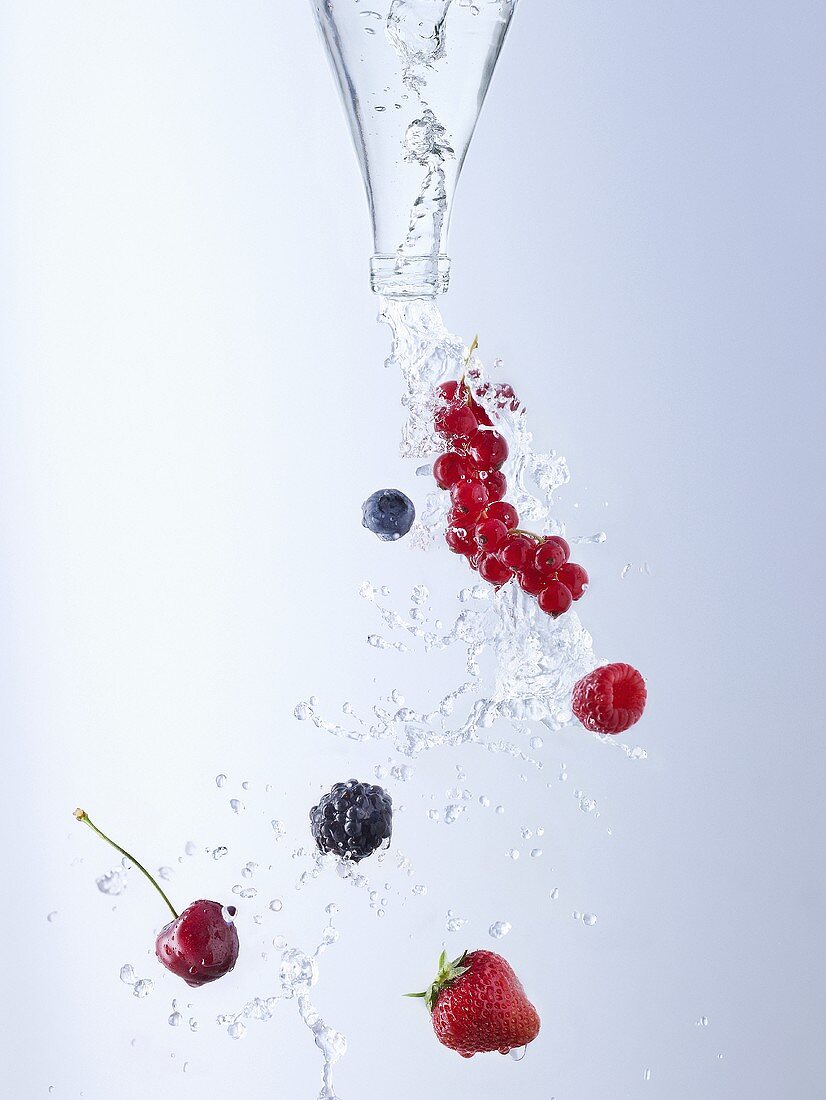 Water and berries pouring out of bottle