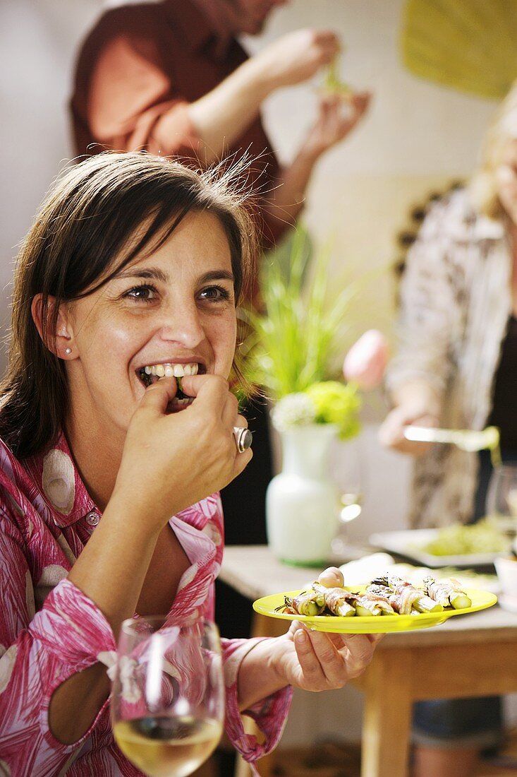 Frau isst Fingerfood auf einer Party