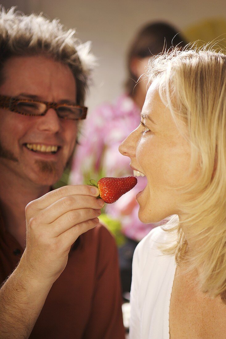 Couple with strawberry at a party