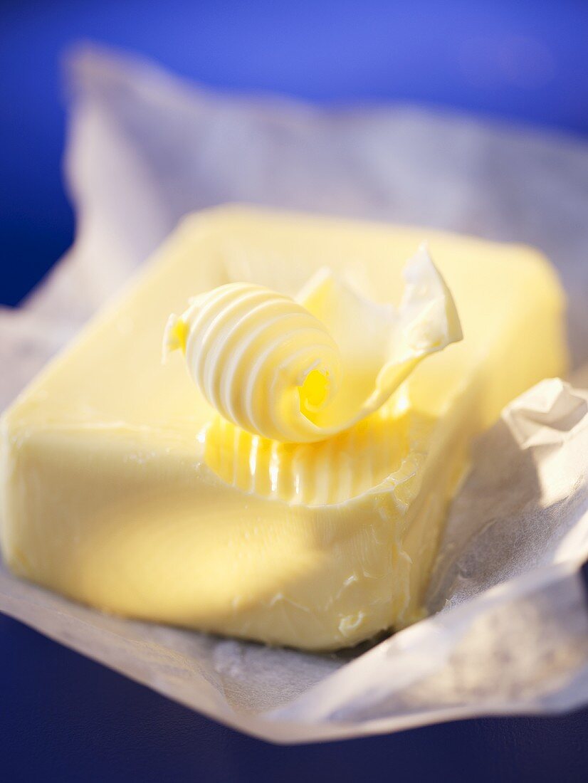 A block of butter with a butter curl