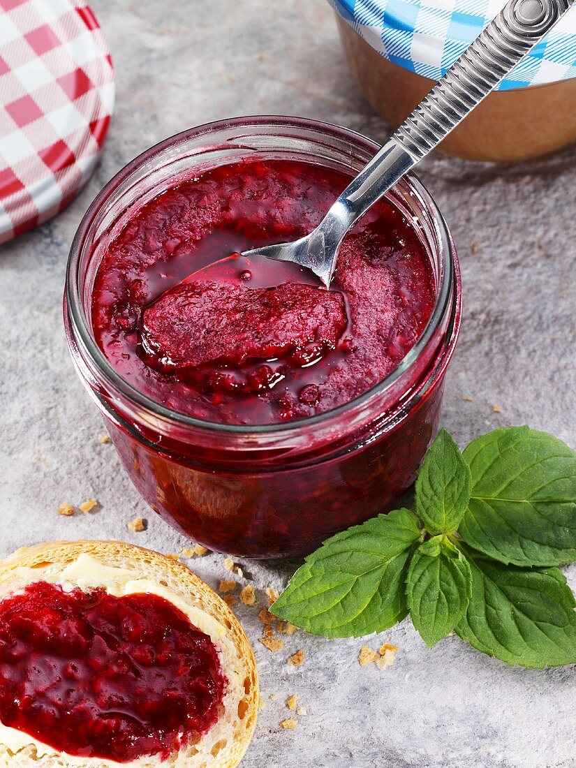 Raspberry jam in jar and on bread