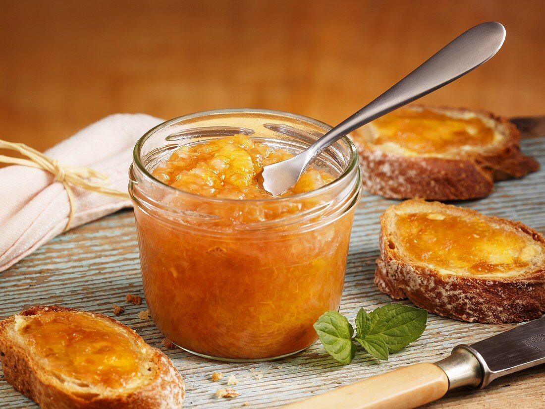 Peach jam in jar and on slices of bread