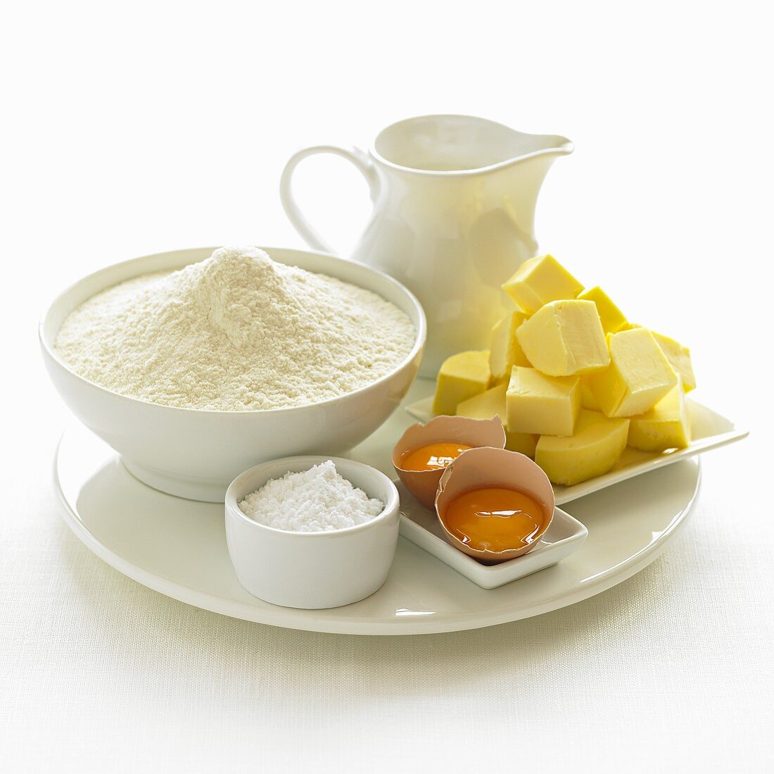 Various baking ingredients (flour, sugar, eggs, butter, milk)