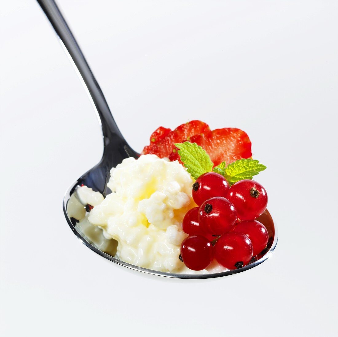 Rice pudding with berries on spoon