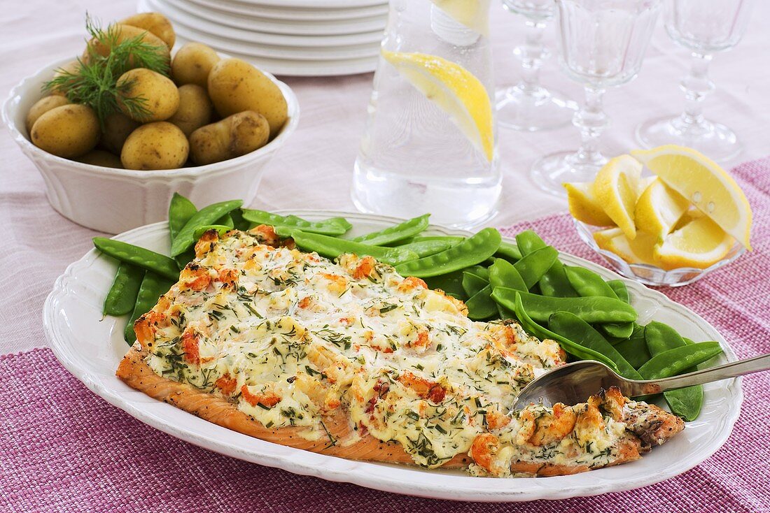 Baked salmon with shrimps, mangetout and potatoes