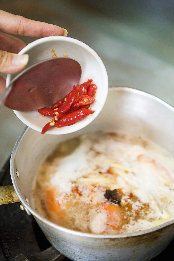Putting chillies into pan (Thailand)