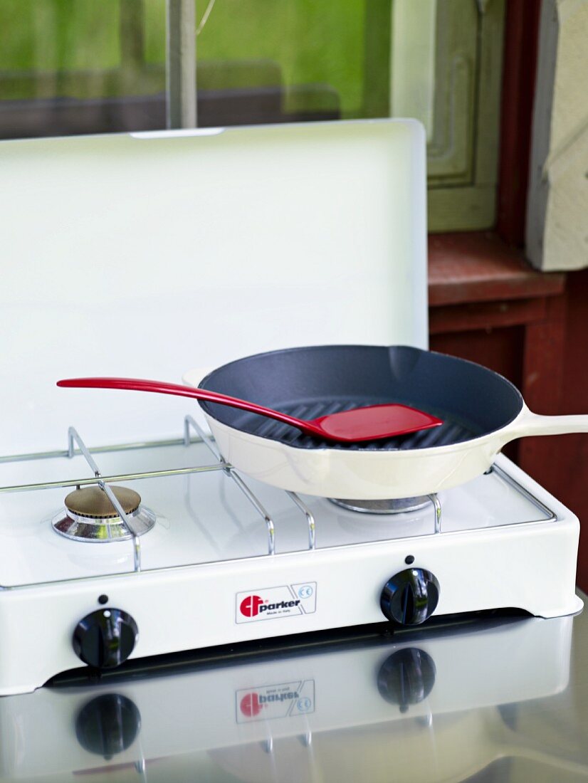 Frying pan and spatula on gas cooker in country home