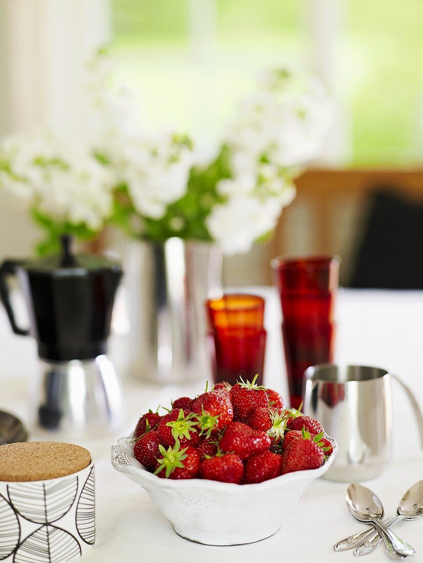 Strawberries in bowl on laid table