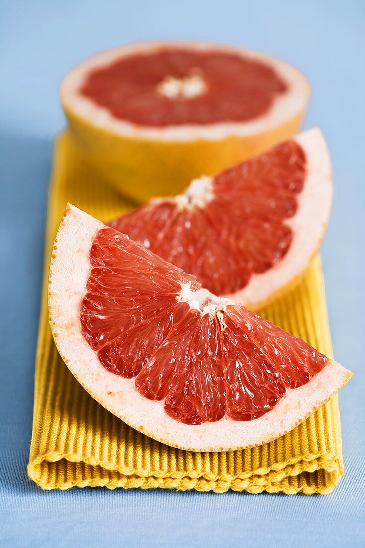 Wedges of grapefruit and half a grapefruit