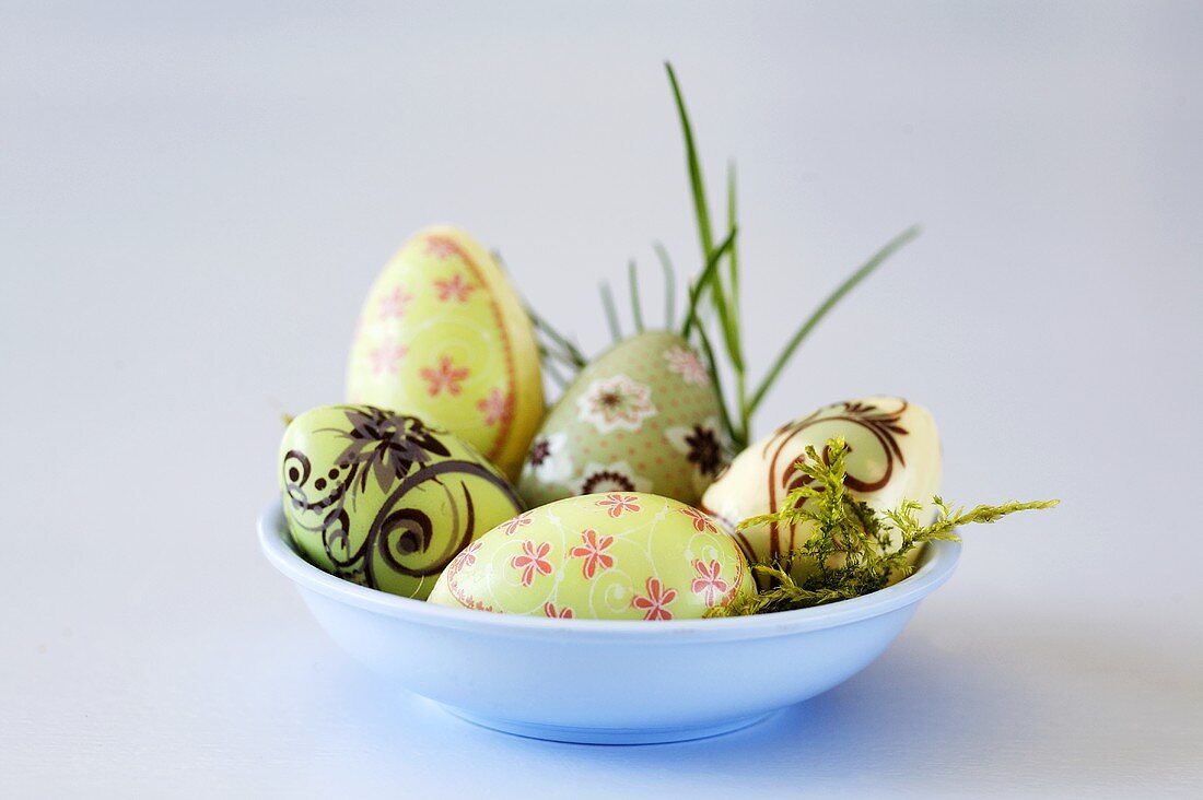 Patterned chocolate Easter eggs in blue dish