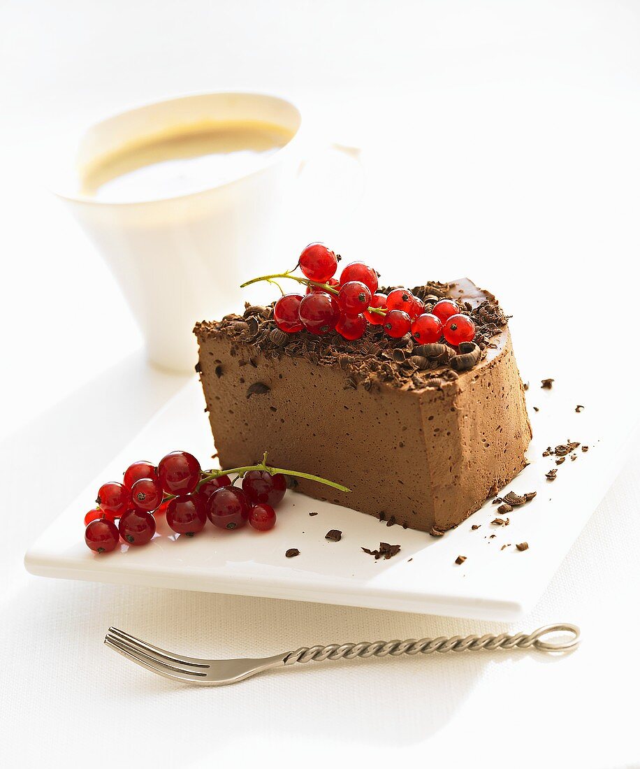 Piece of chocolate cheesecake with redcurrants