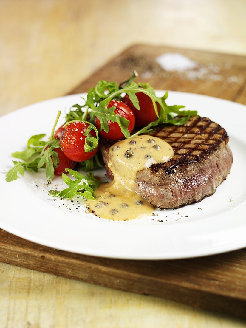 Fillet steak with pepper sauce, cherry tomatoes and rocket