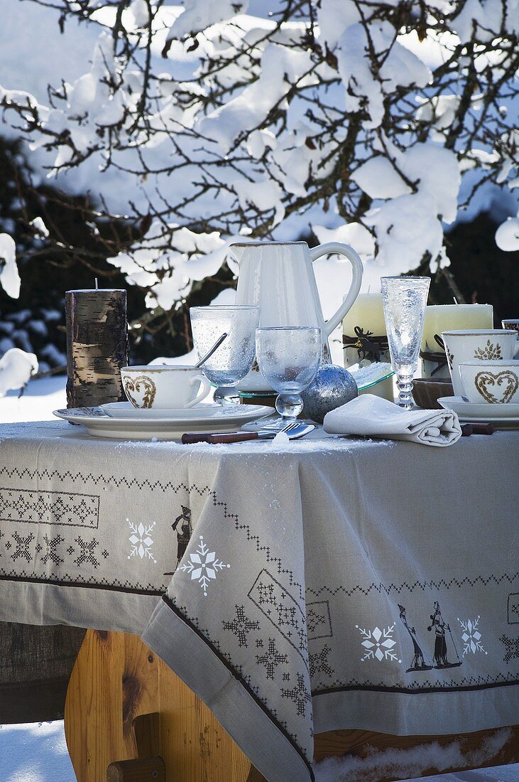 Gedeckter Tisch im winterlichen Garten (weihnachtlich)